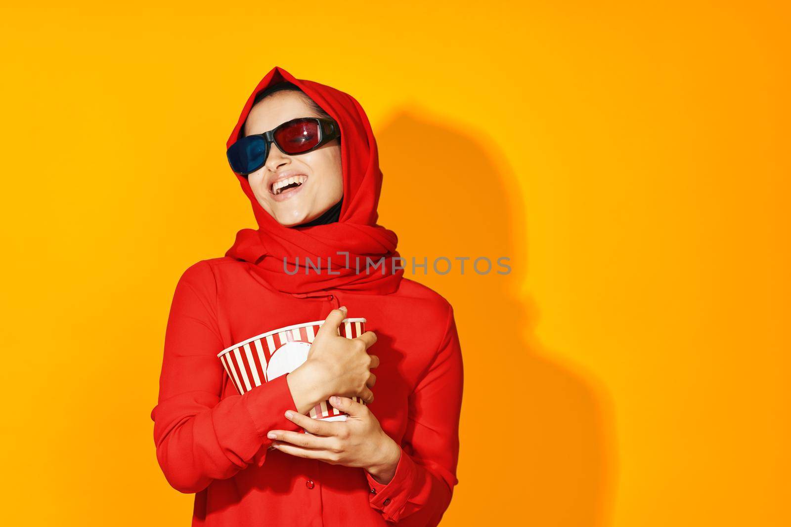 woman in red hijab 3d glasses technology watching movie popcorn yellow background by Vichizh