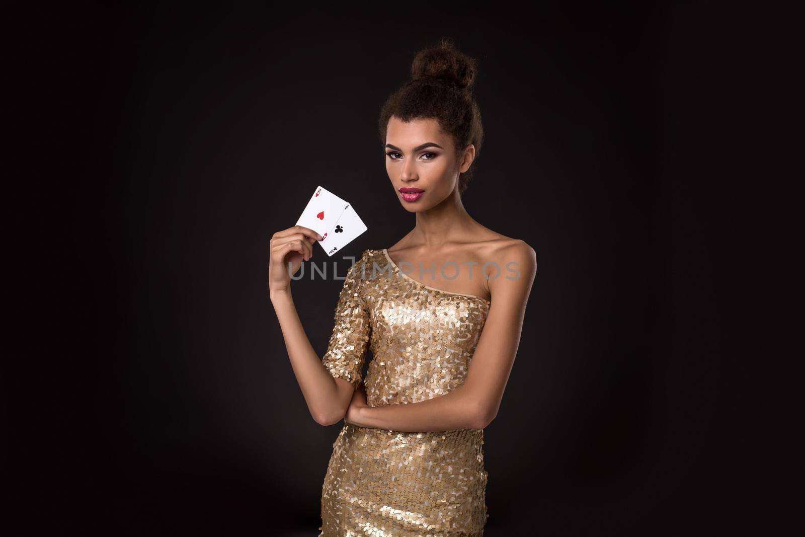 Pretty african girl shows two aces in casino poker and win Young woman in studio on black background