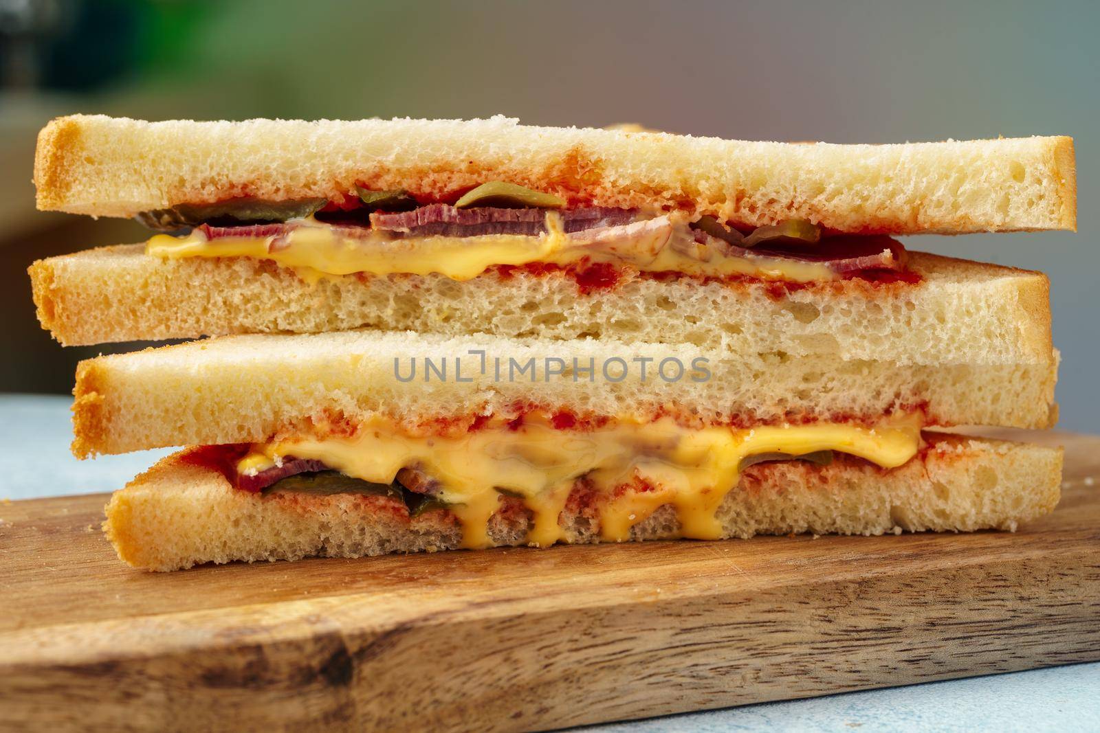 Grilled club sandwich on wooden board on gray background, close up