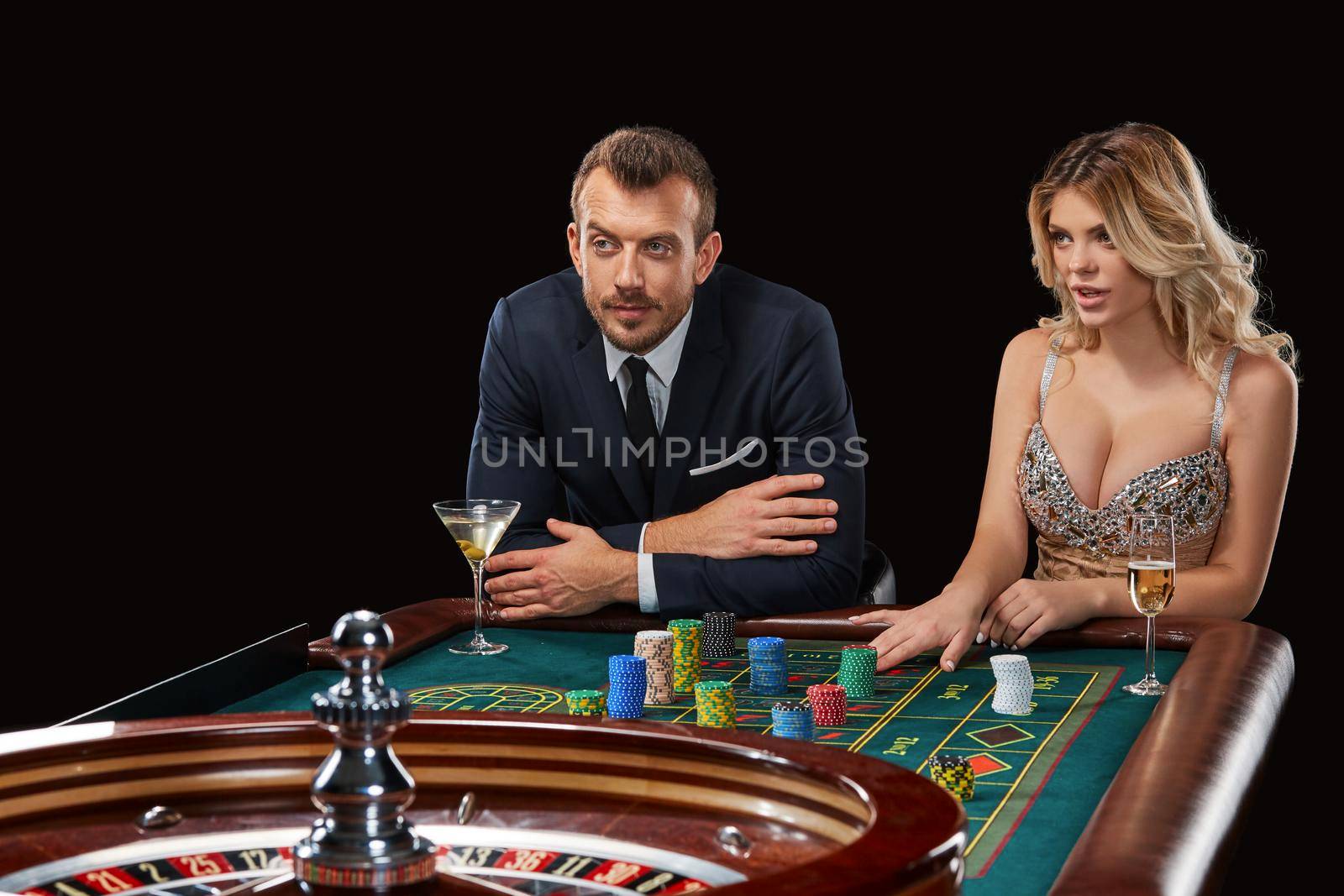 Couple playing roulette wins at the casino. Addiction to the gambling. Girl bets chips