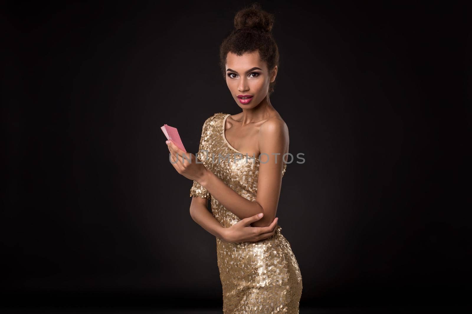 Woman winning - Young woman in a classy gold dress holding two cards, a poker of aces card combination. Emotions by nazarovsergey