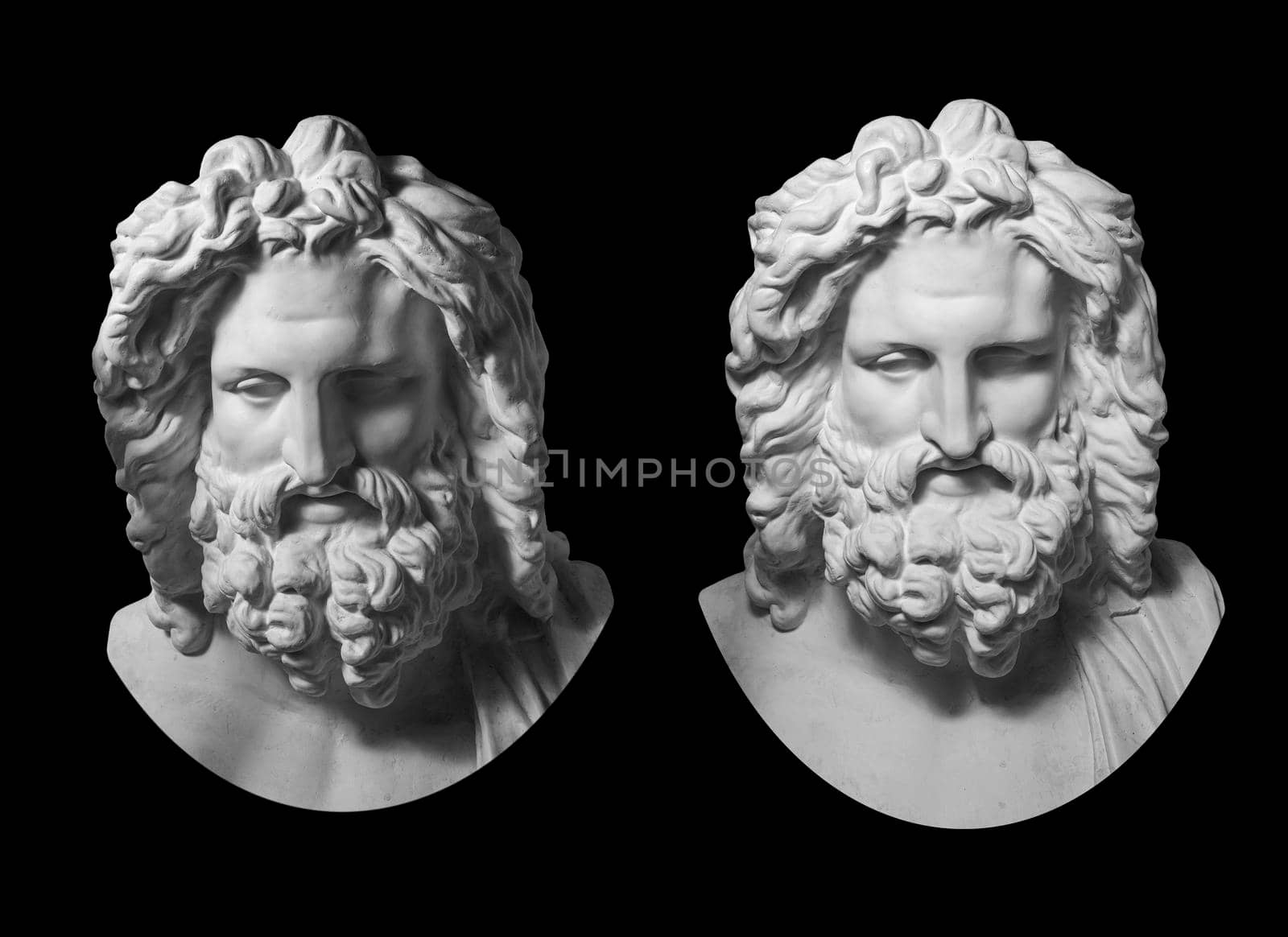 Two white gypsum copy of antique statue of Zeus head for artists isolated on a black background. Plaster sculpture of man face with beard. Zeus the ancient Greek god.