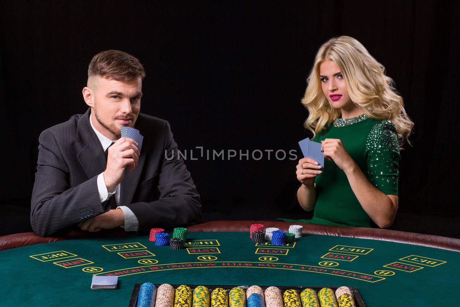 couple playing poker at the table by nazarovsergey