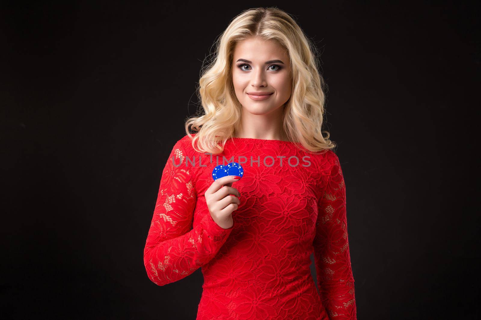 Young beautiful blond woman with poker chips over black. Poker by nazarovsergey