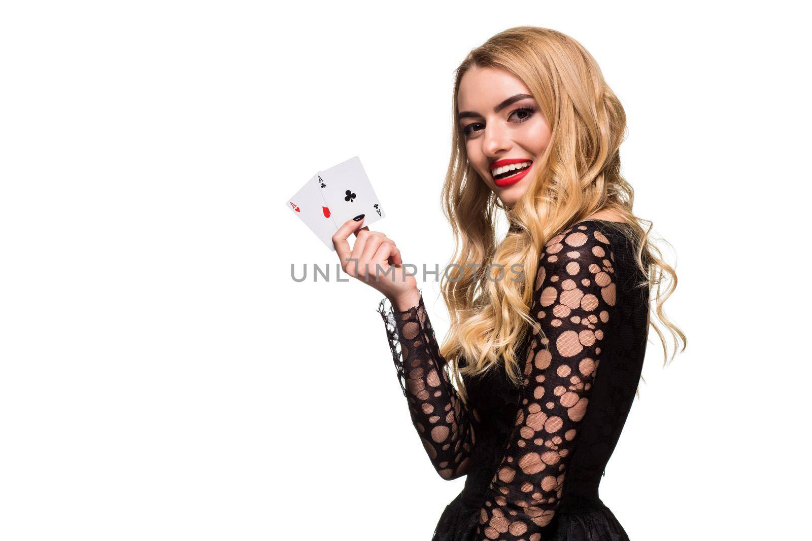 Beautiful blonde in a black dress with casino cards two aces in hands isolated on a white background. Poker. Casino. Roulette Blackjack Spin. Caucasian young woman looking at the camera. Winning combination emotions