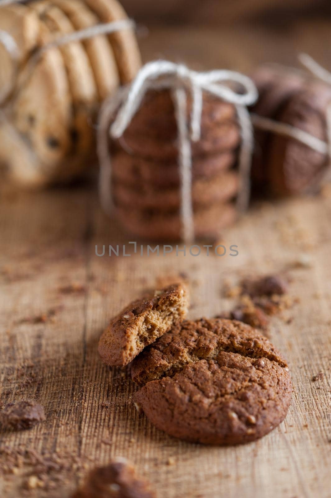 Homemade corded wholegrain cookies with oatmeal, linen and sesame seeds and traditional american cookies with chocolate chips on dark rustic wooden table . Healthy vegan food concept.