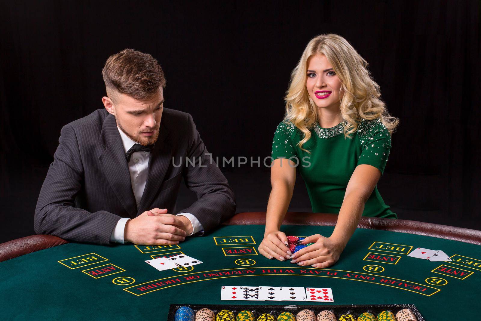 couple playing poker at the table. by nazarovsergey