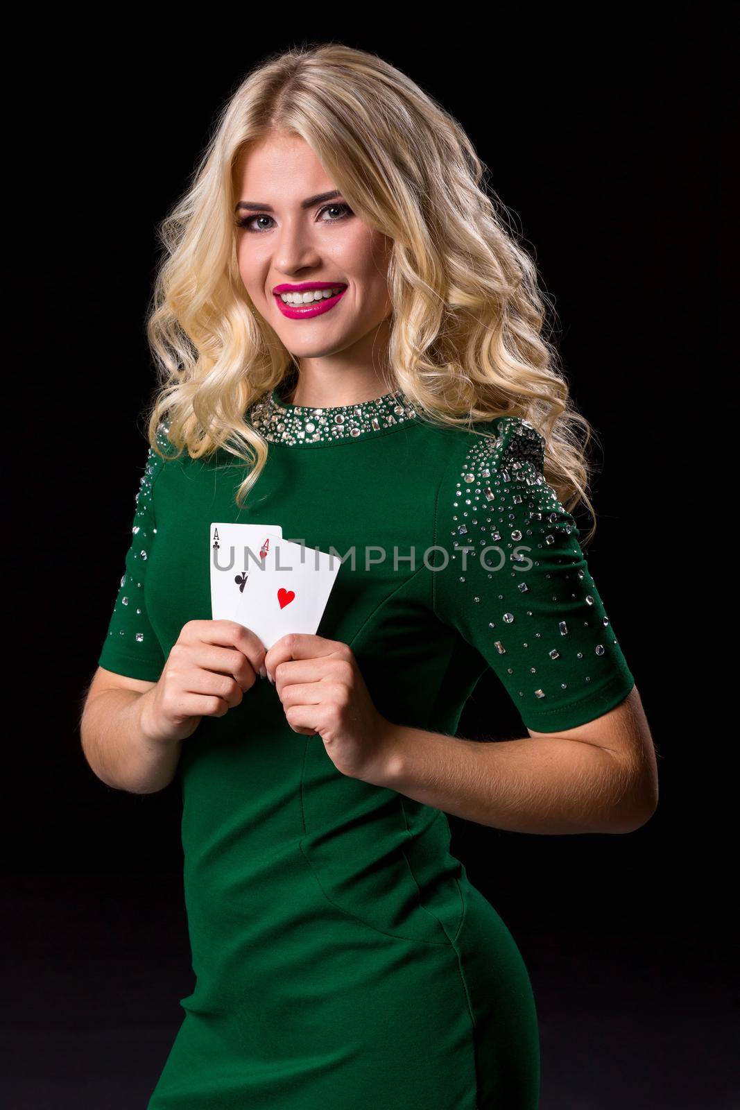 blonde woman in posing with cards for gambling on black background