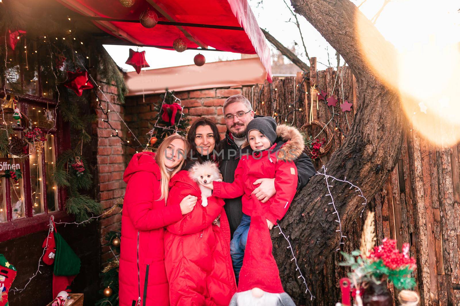 Happy family on the porch of the Christmas decorated house outdoor by Len44ik