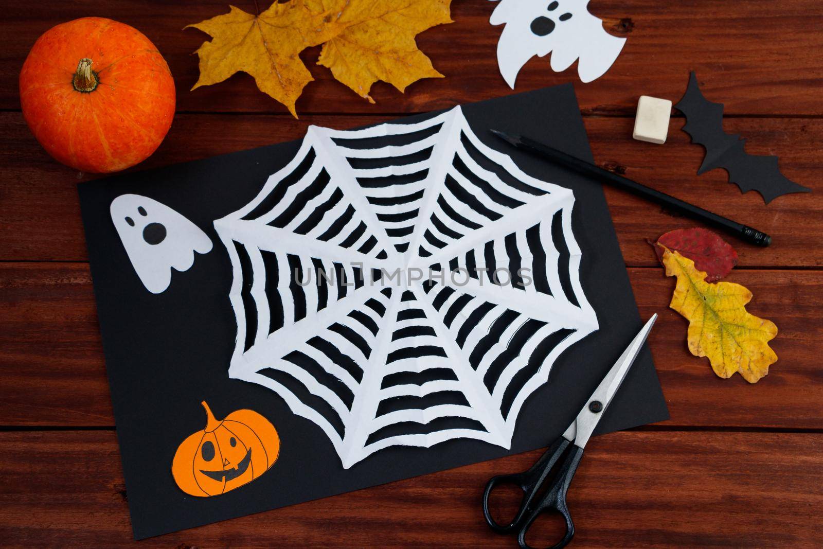 Halloween DIY. Spider web cut from paper. Children's creativity.