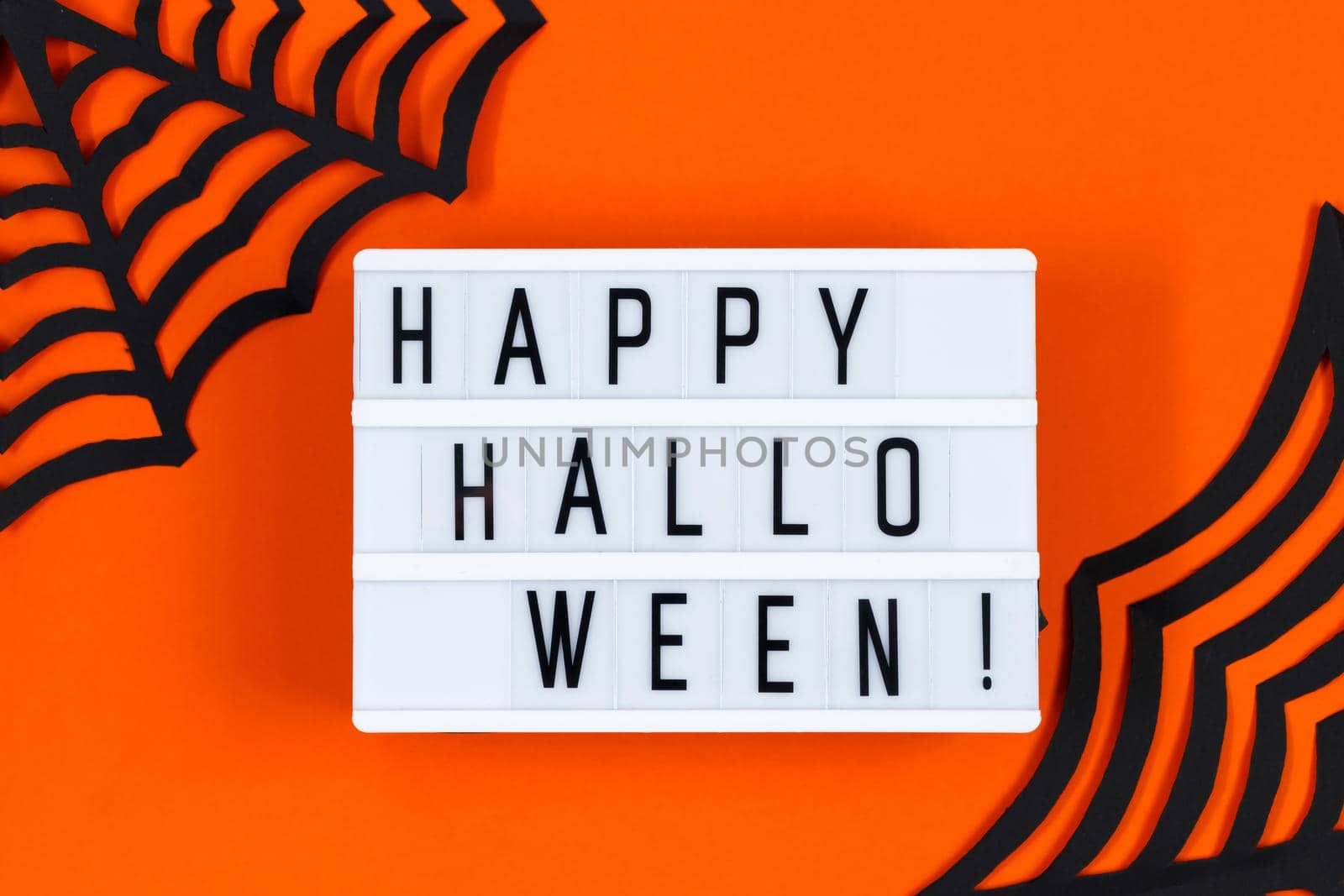 Happy Halloween. Paper decor for the holiday on an orange background. Place for text.