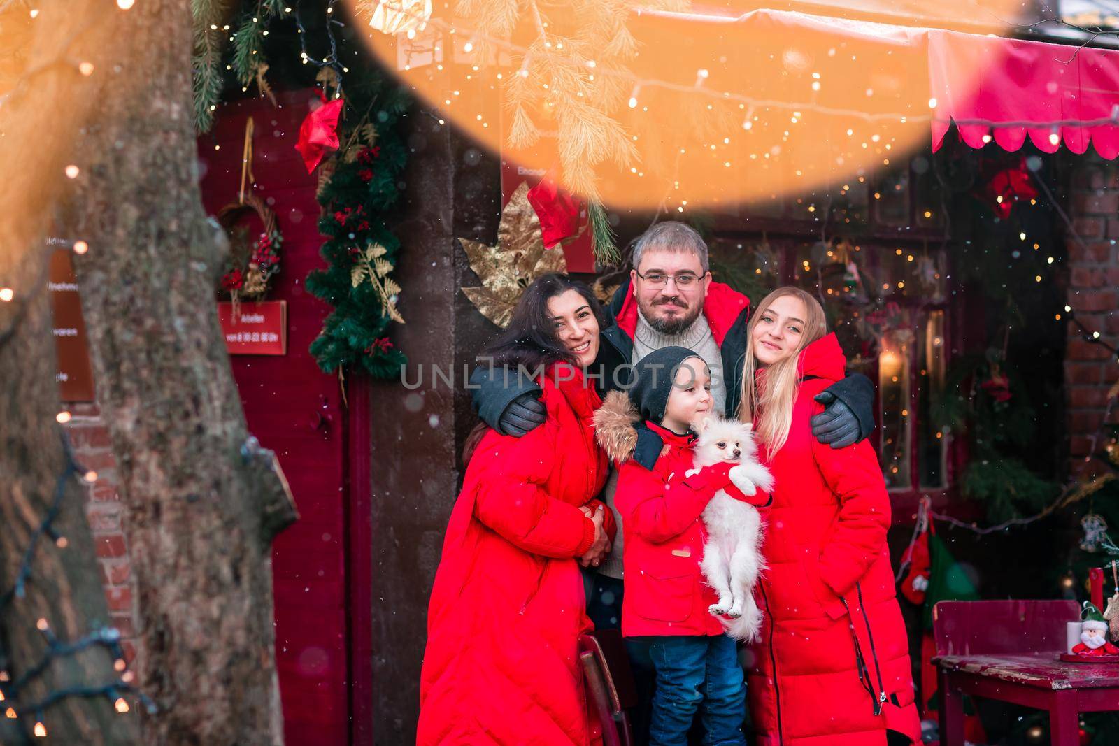Happy family on the porch of the Christmas decorated house outdoor by Len44ik