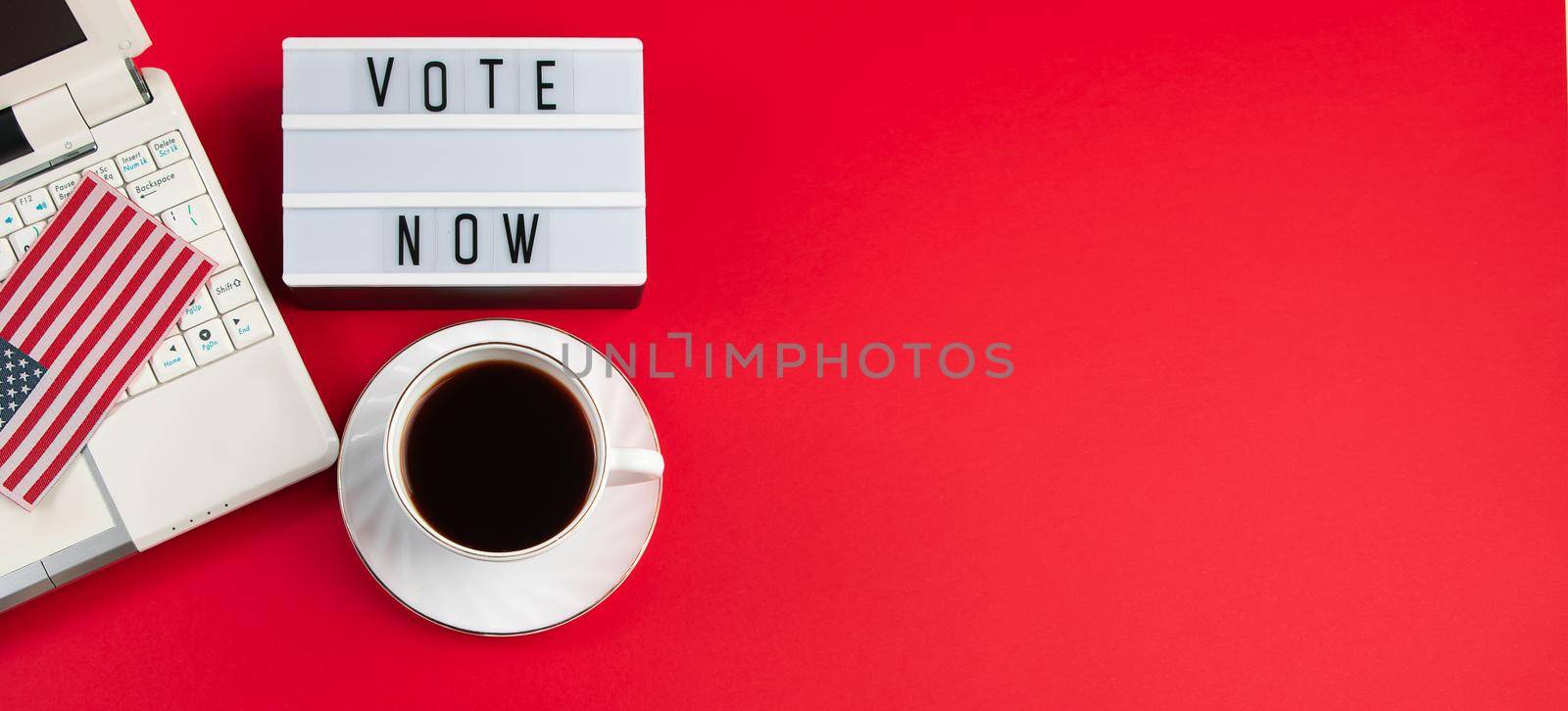 Online voting and elections concept. Laptop and coffee cup on red background. Place for text. by Statuska