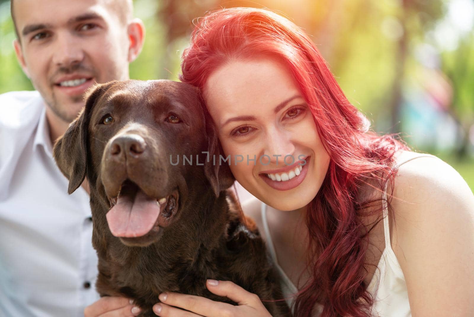 A couple and their dog in the park. Spending time with friends