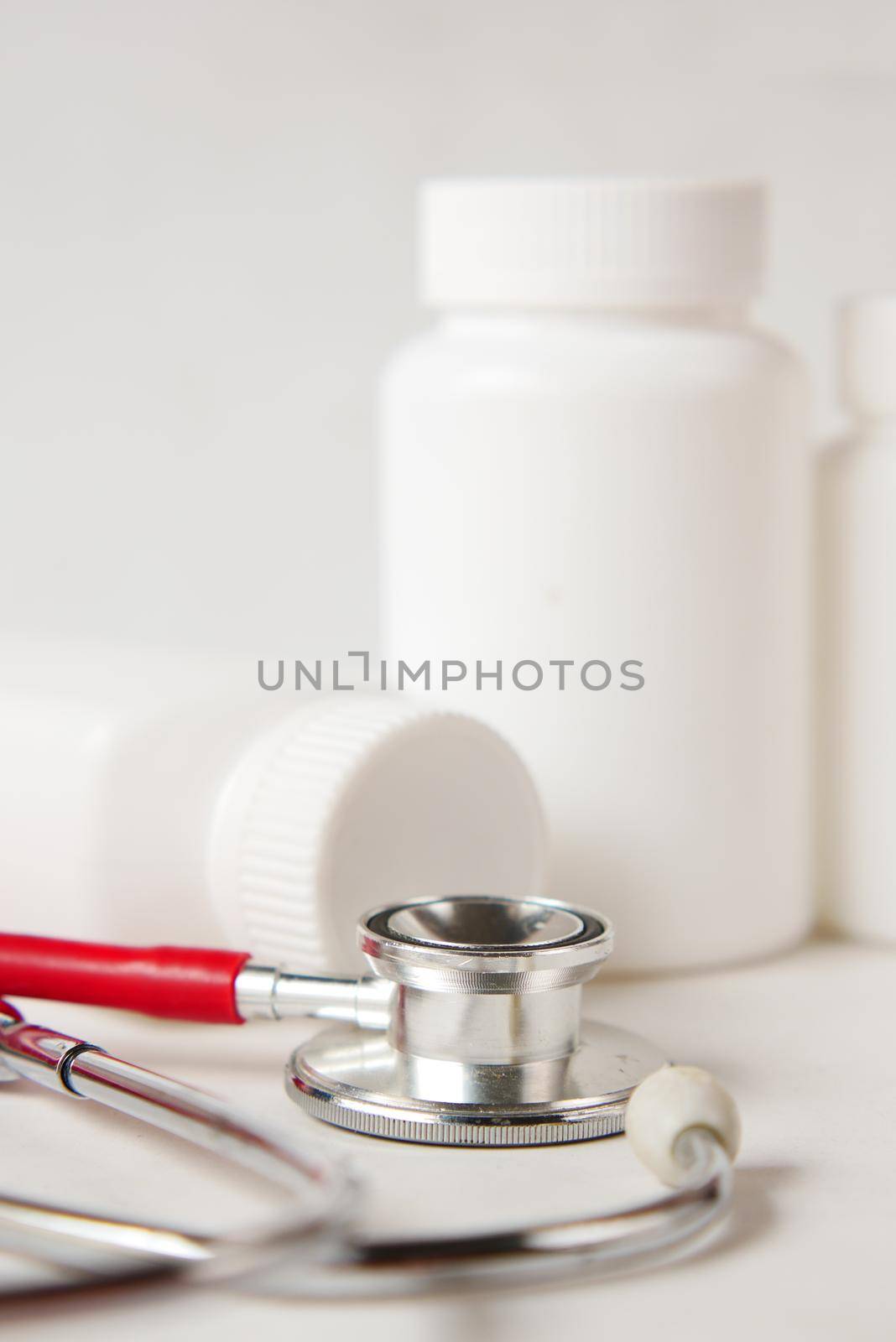 medical pill container and stethoscope on white background .