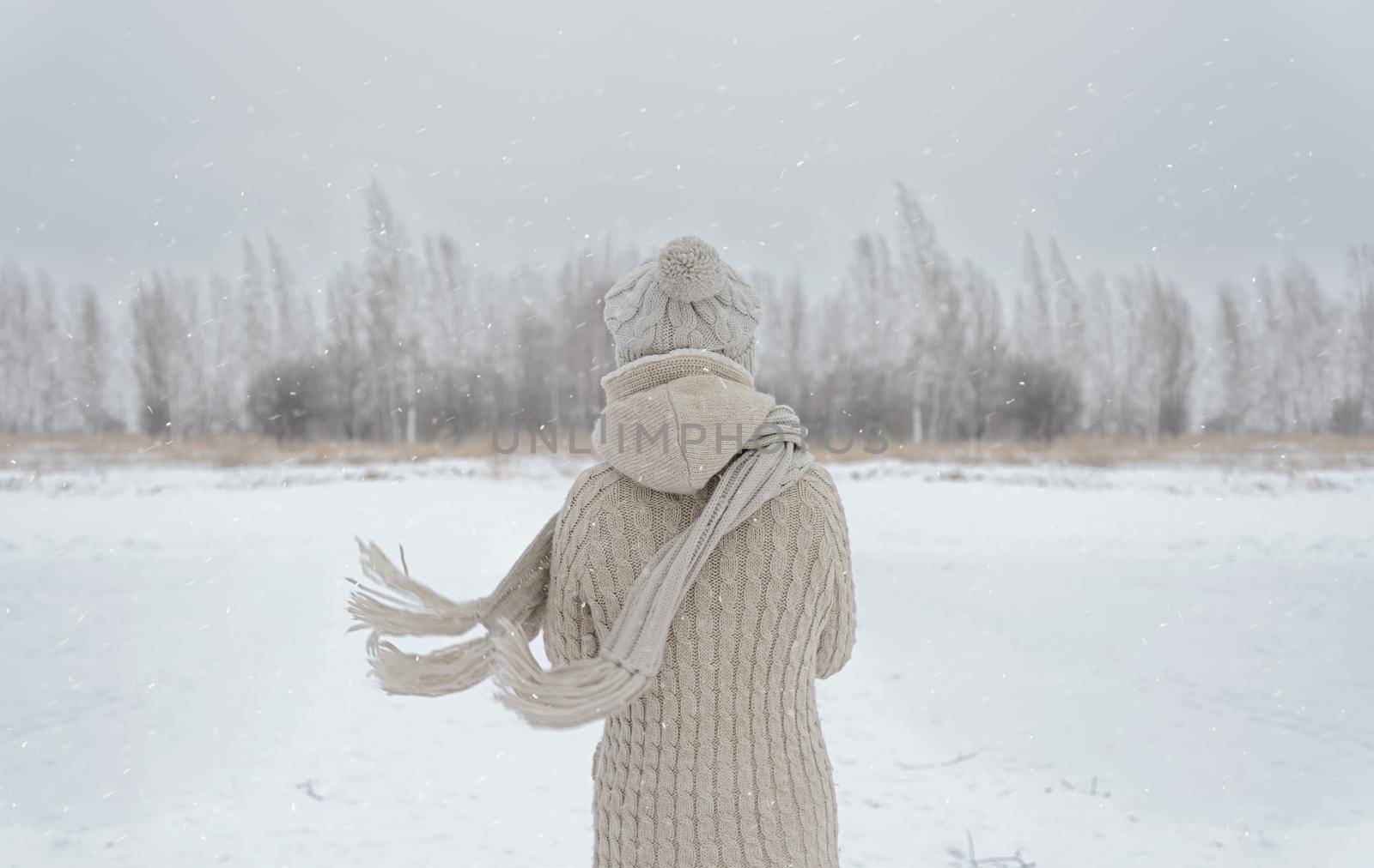 Unrecognizable woman stands back in the woods in winter