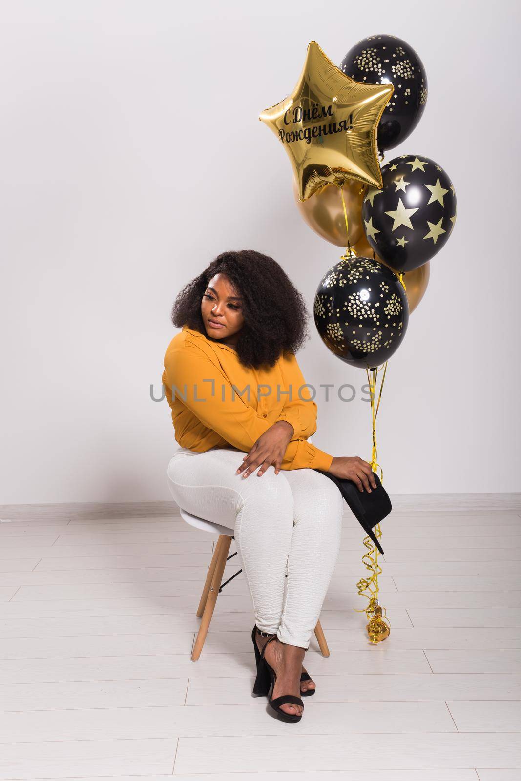 Holidays, party and fun concept - Portrait of smiling young African-American young woman looking stylish on white background with balloons. by Satura86