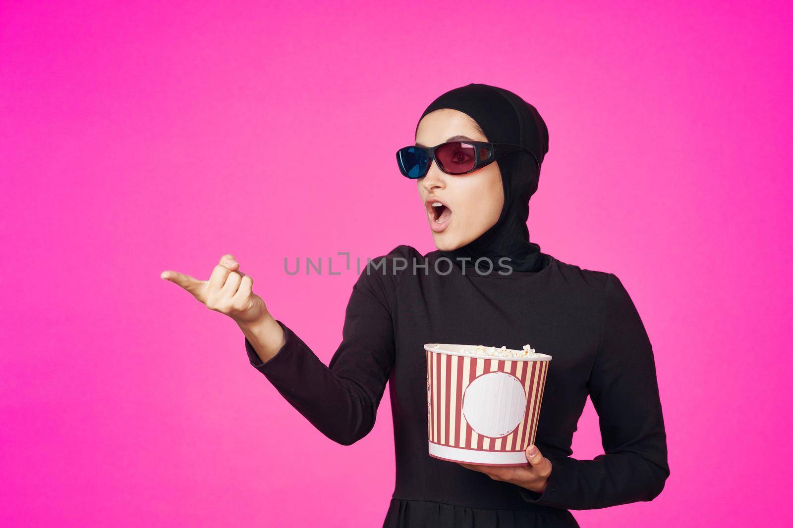 pretty woman in 3D glasses popcorn entertainment movies purple background. High quality photo