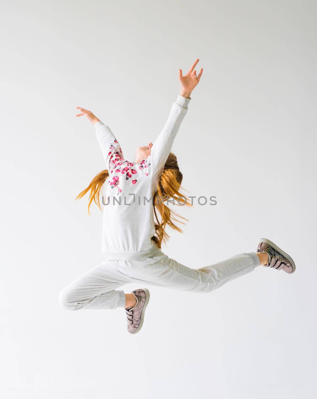 Teenage girl do a split leap in the air. by GekaSkr