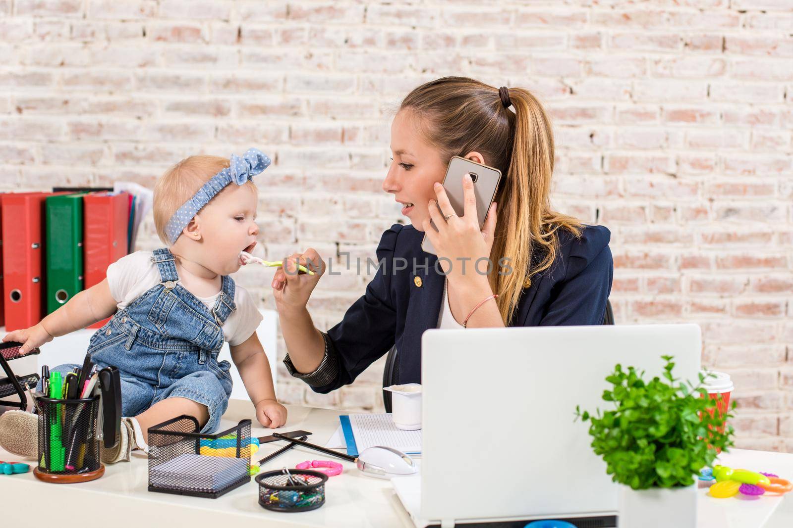 Family Business - telecommute Businesswoman and mother with kid is making a phone call by nazarovsergey
