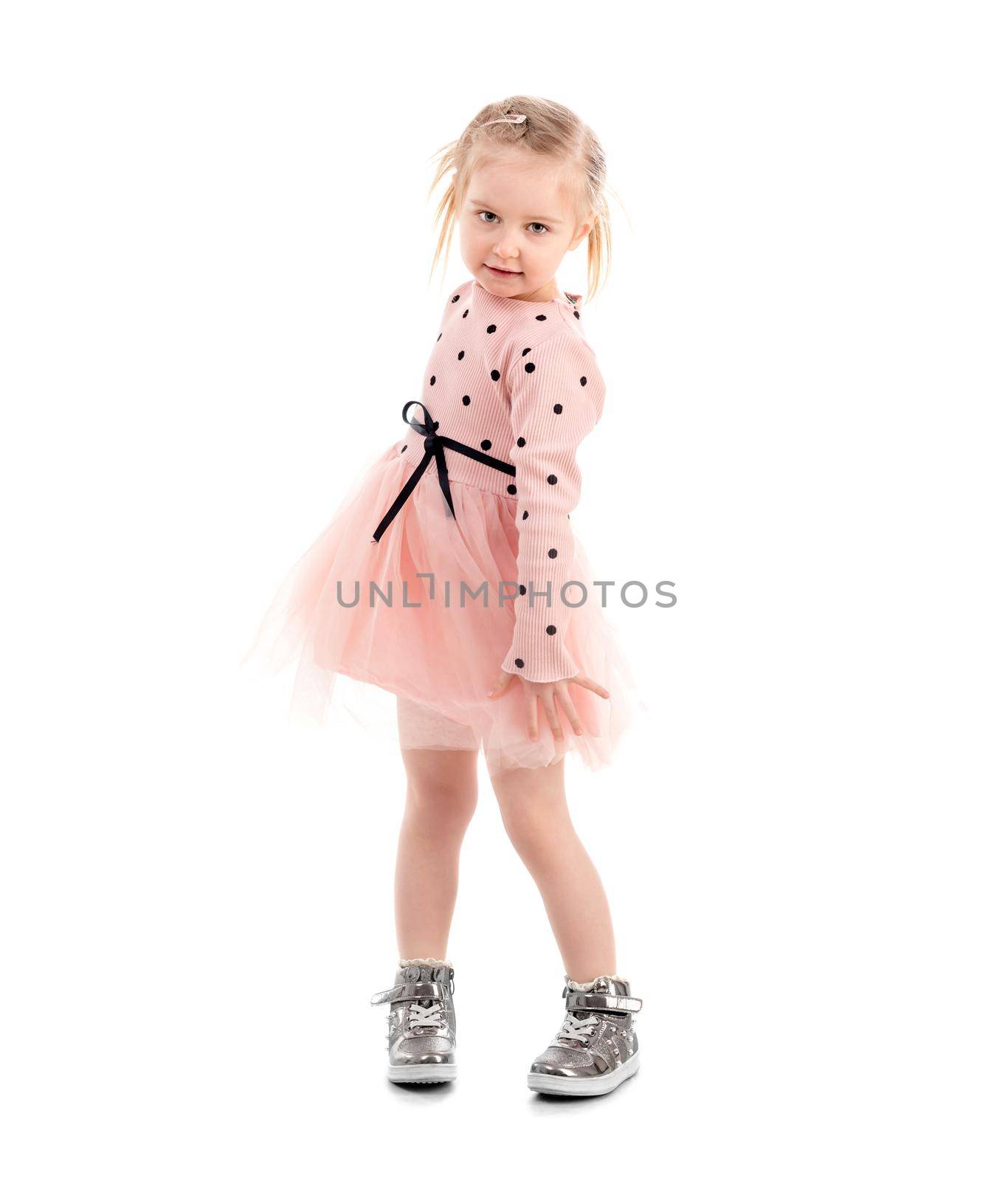 Amazing kid with lovely hairstyle moving around, turning and spinning, isolated, cute outfit