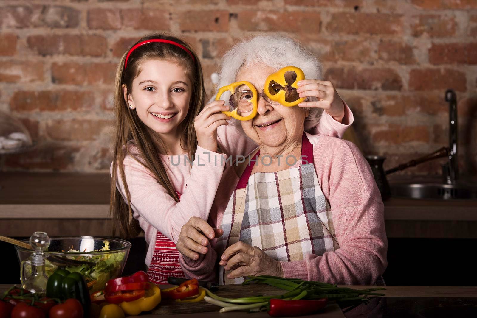 Grandchild with granny having fun while cooking at home