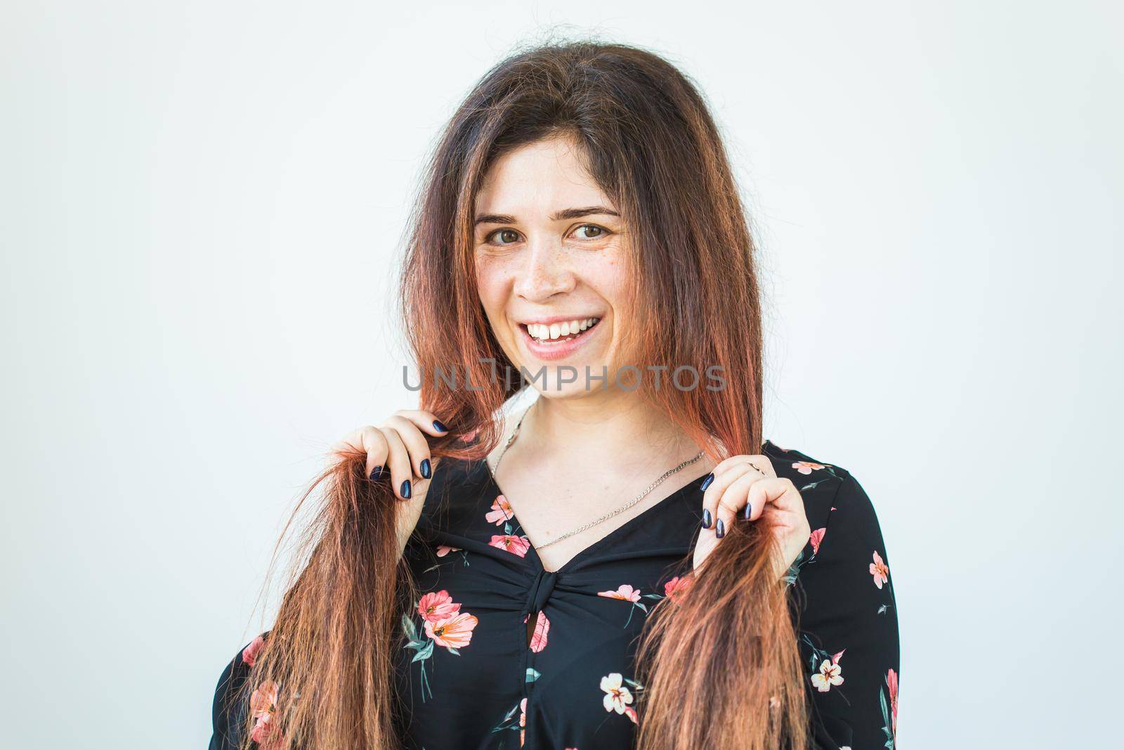 Close up portrait of funny attractive pretty girl with long ginger fair hair standing on white background