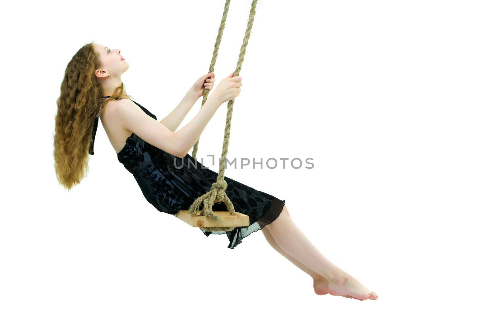 School-age teenage girl swinging on a swing. The concept of rest after class. Isolated on white background.