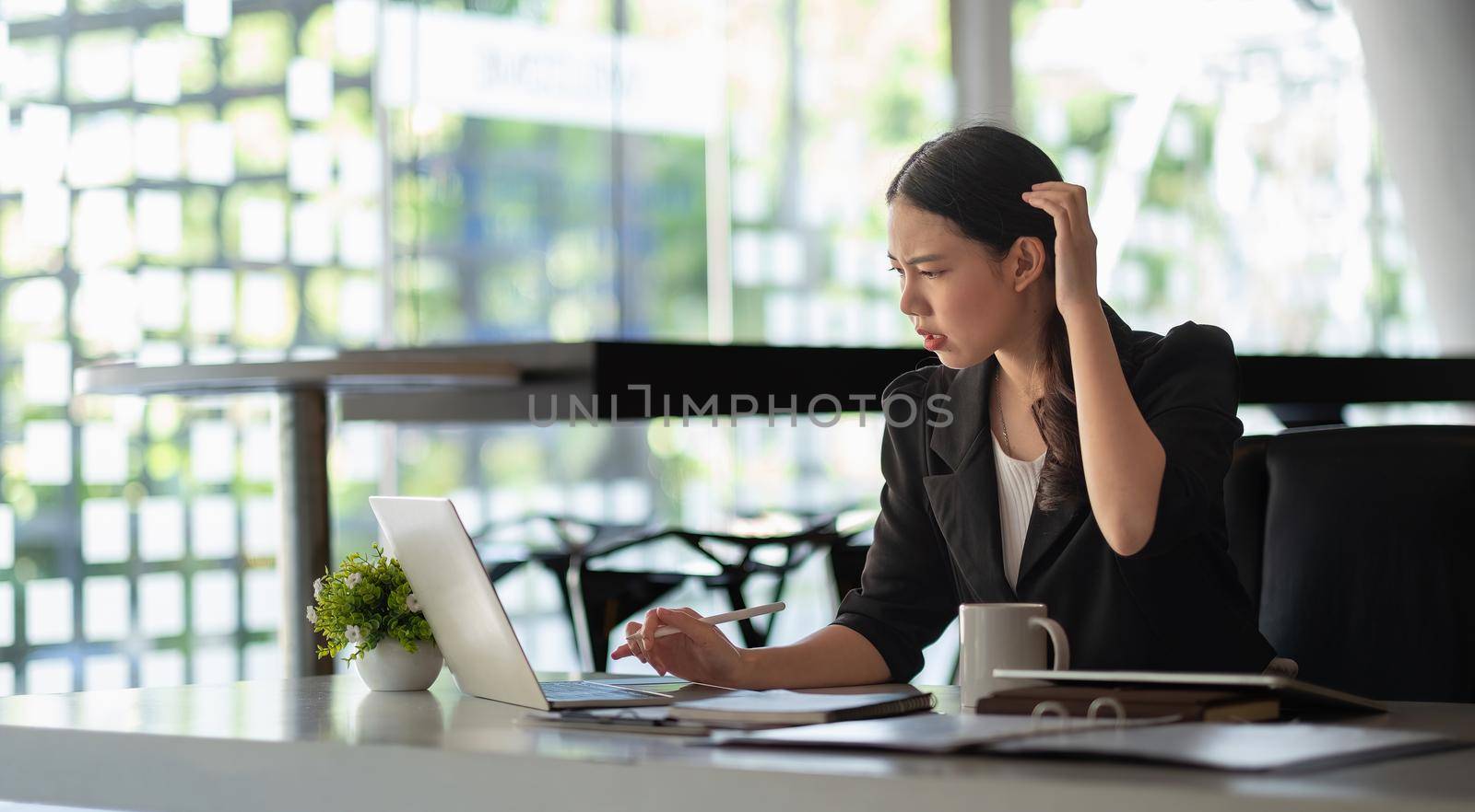 asian business woman thinking solving problem at work, worried serious young asian woman concerned make difficult decision lost in thought reflecting sit with laptop