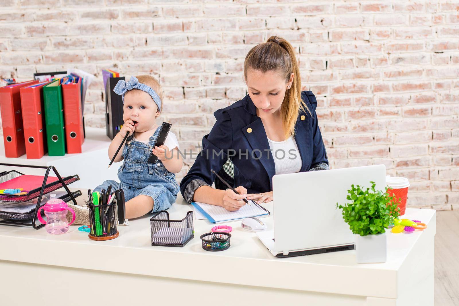 Businesswoman mother woman with a daughter working at the laptop by nazarovsergey