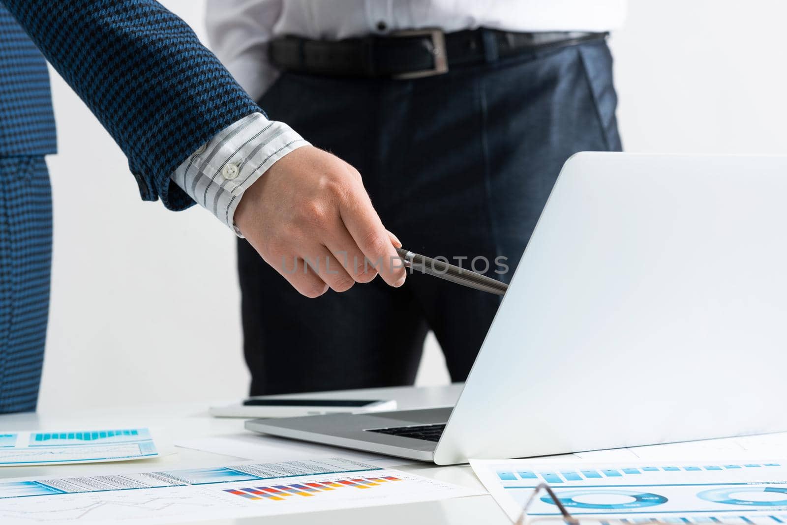 Businessman and businesswoman stand near desk with financial annual report. Business people meeting in conference room. Business idea presentation and analysis. People communication and discussion