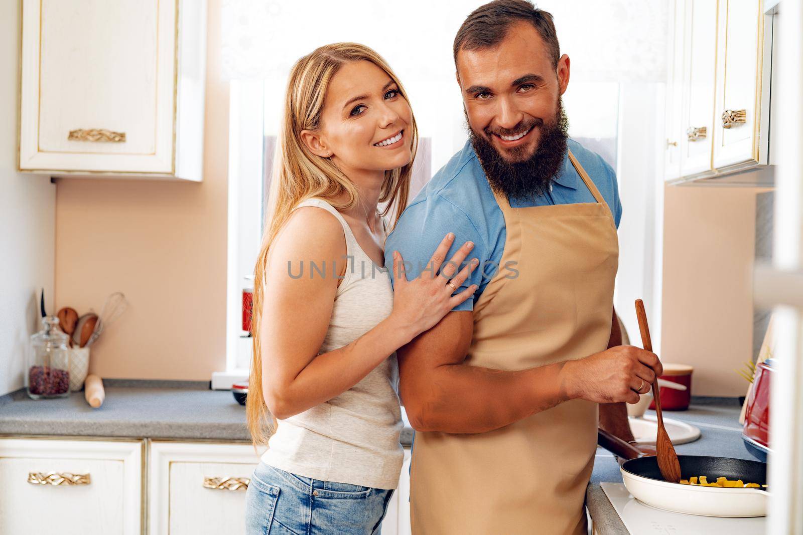 Young loving couple cooking together in kitchen at home