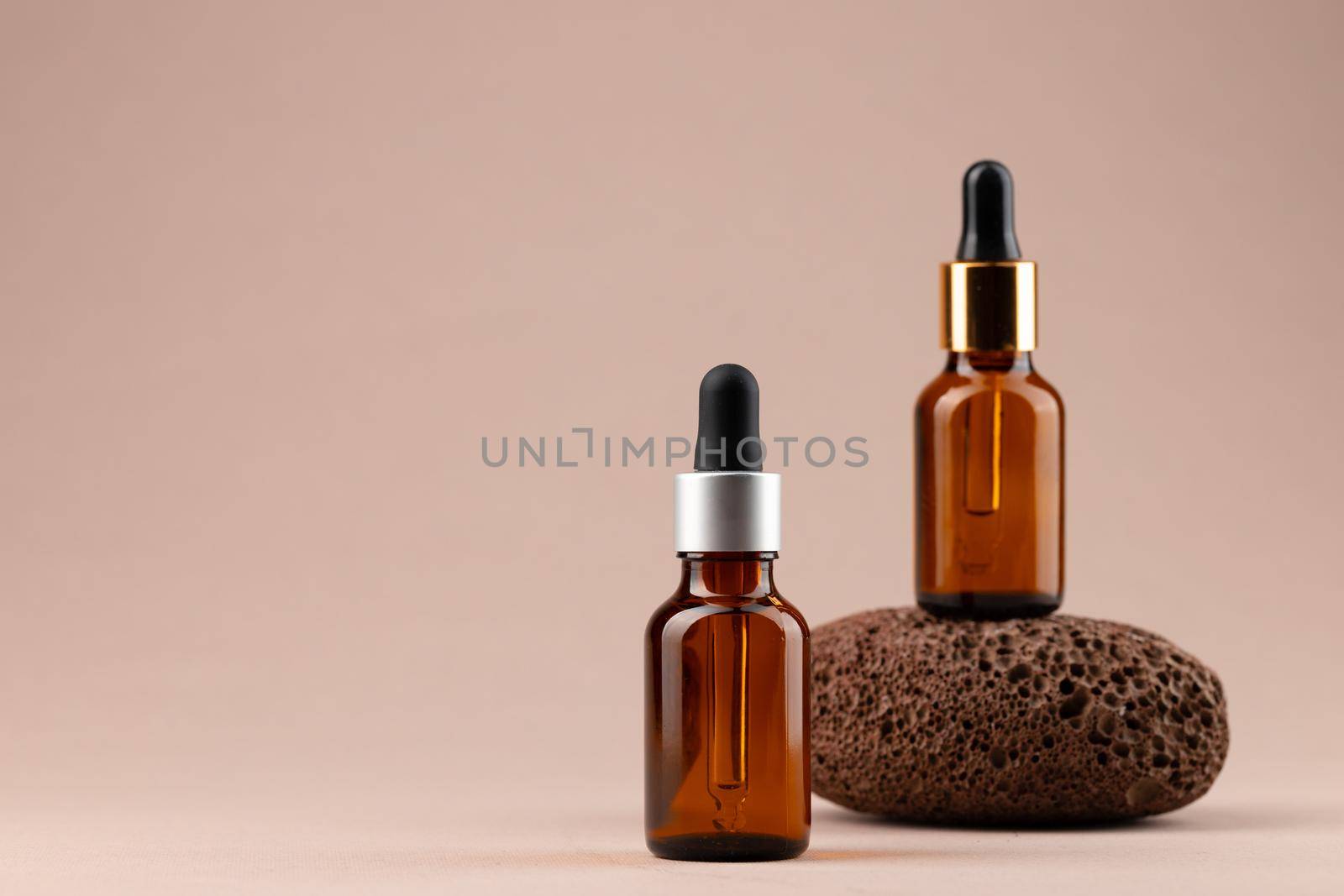 Beauty oil bottle with pipette on beige background close up