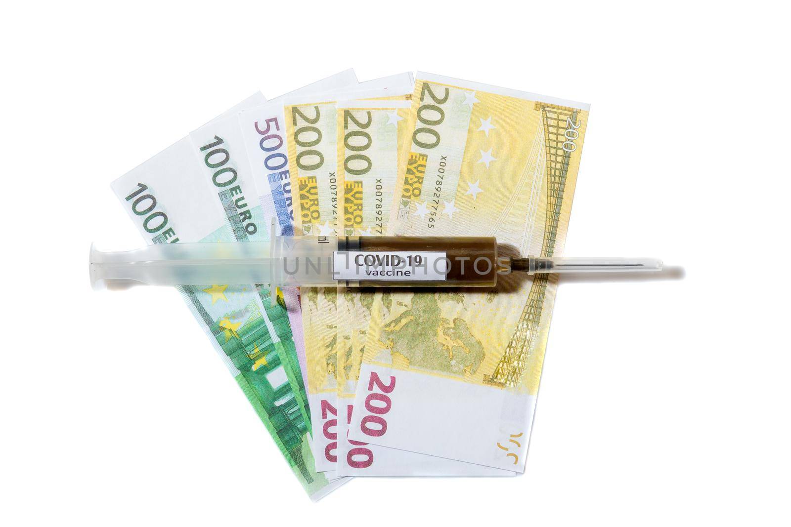Close up view of needle on a syringe filled with vaccine laying on a euro banknote. Isolated on white background