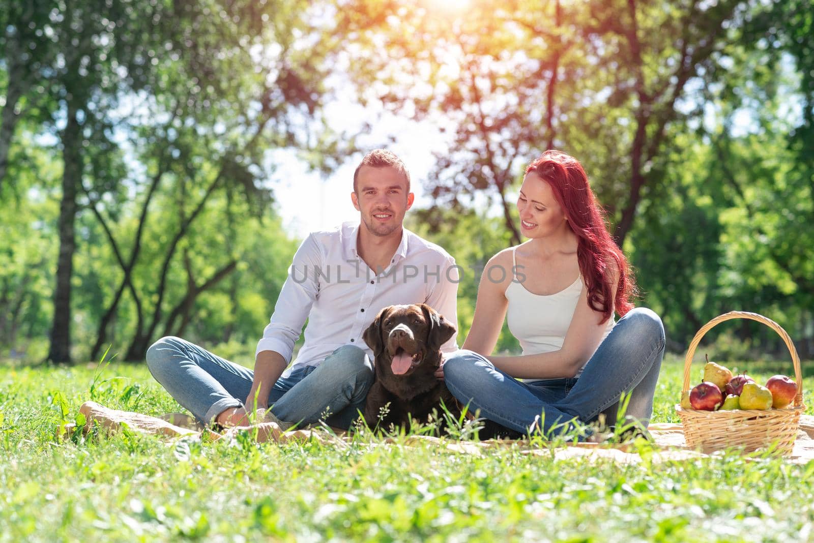 A couple and their dog in the park. Spending time with friends