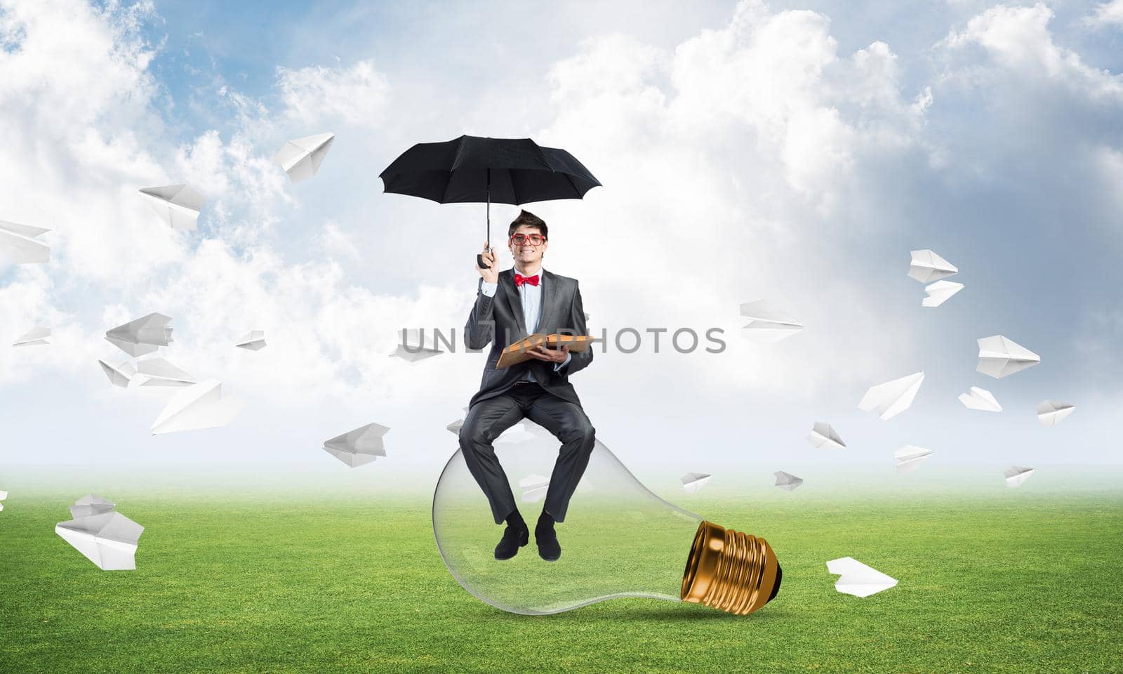 young businessman with umbrella and book, around fly in chaos paper plane