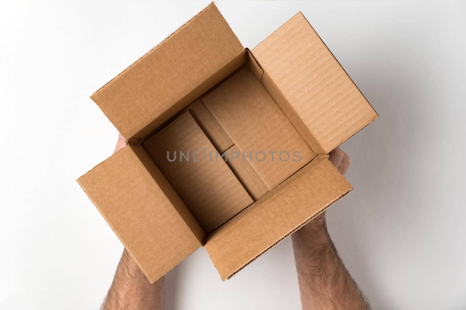 Empty open cardboard box in mens hands. Service delivery concept. White background