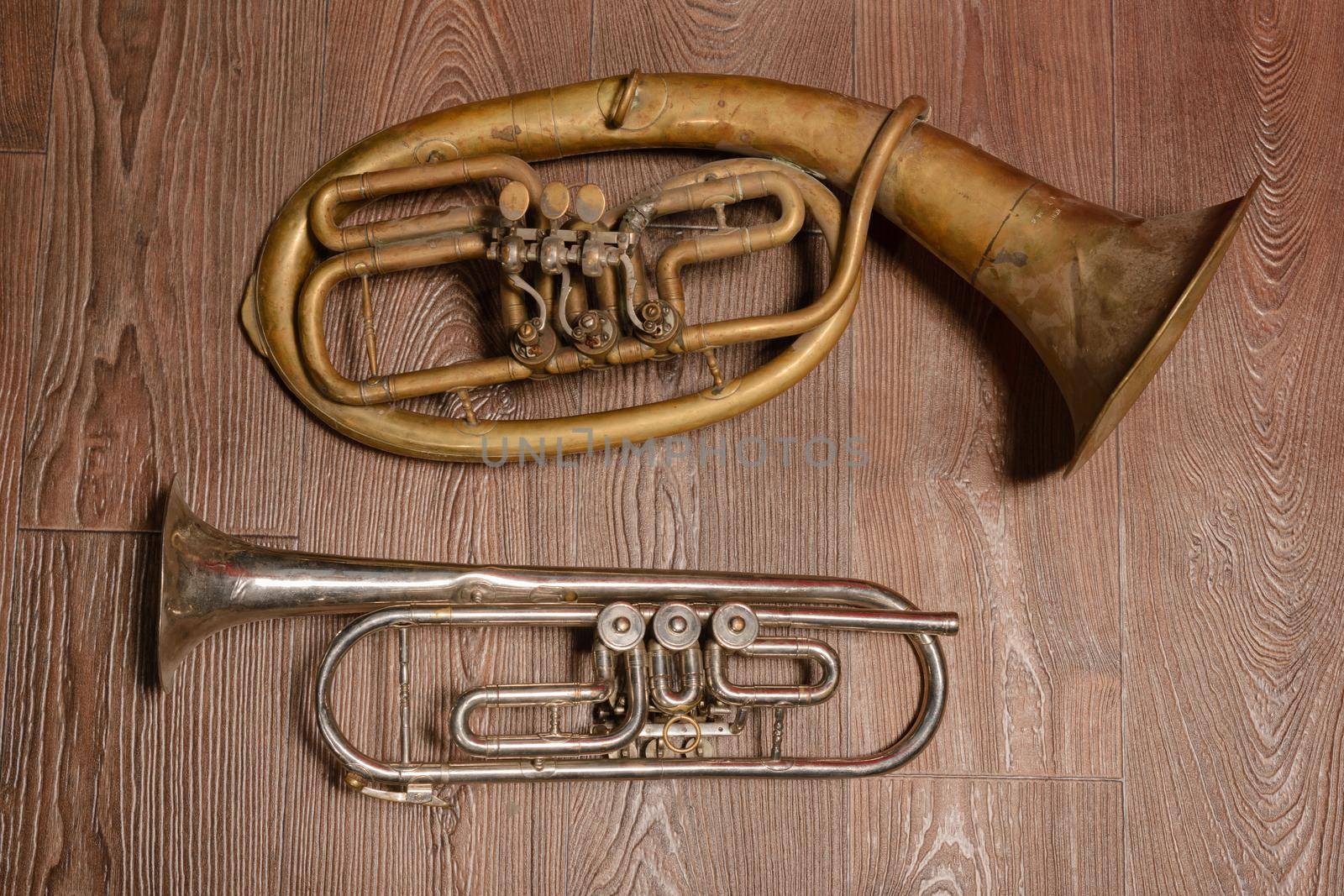 old brass wind instrument and horn on a wooden background. studio