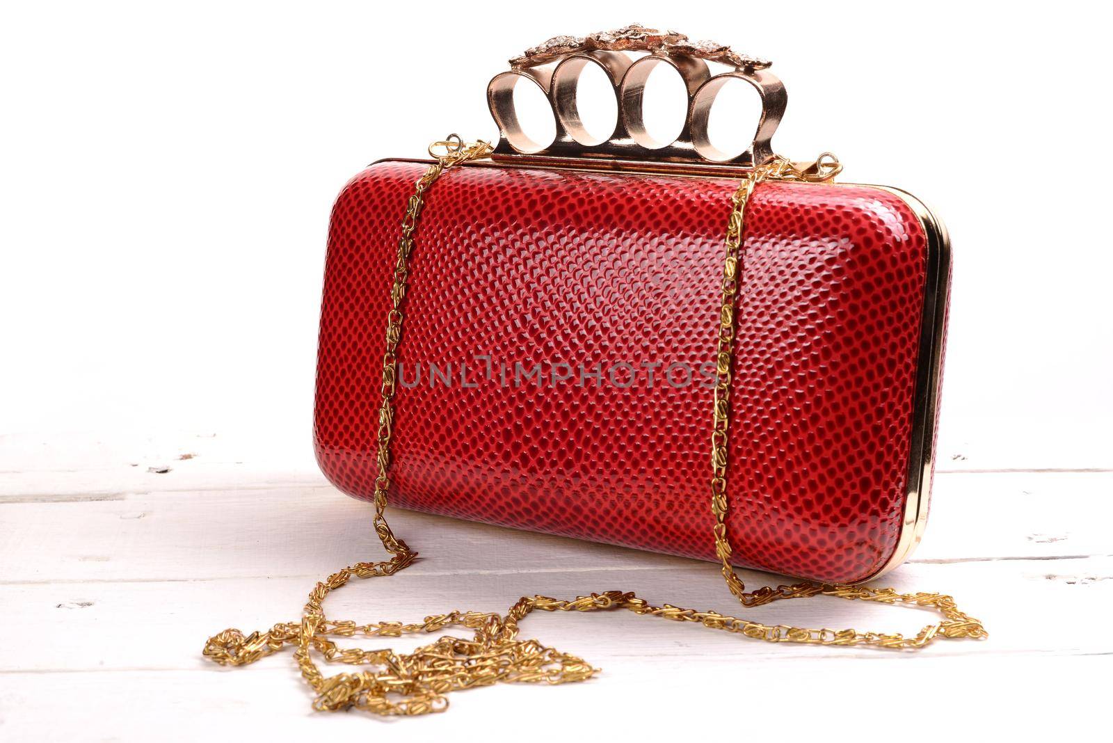 Red wallet purse with brass knuckles on white background by zartarn