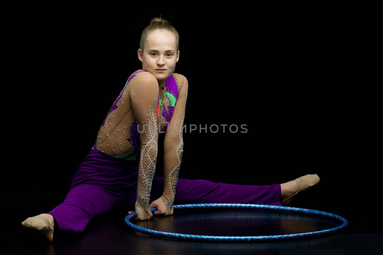 A girl gymnast performs an exercise with a hoop. The concept of gymnastics and fitness. Isolated.