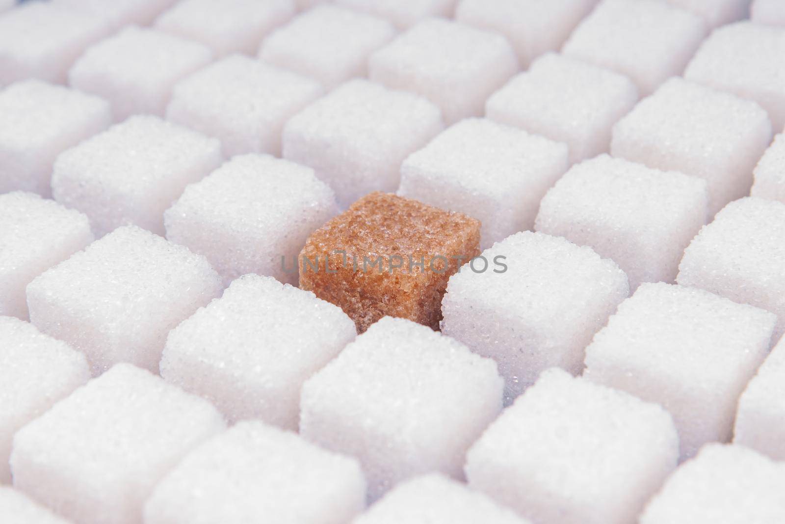 Many cubes of white sugar with one other. Concept not like everyone
