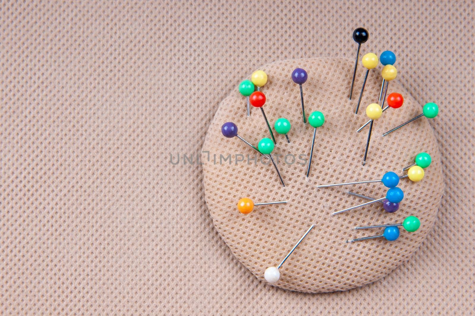 Multi-colored pins for sewing in a pillow for pins. Needlework concept. by chelmicky