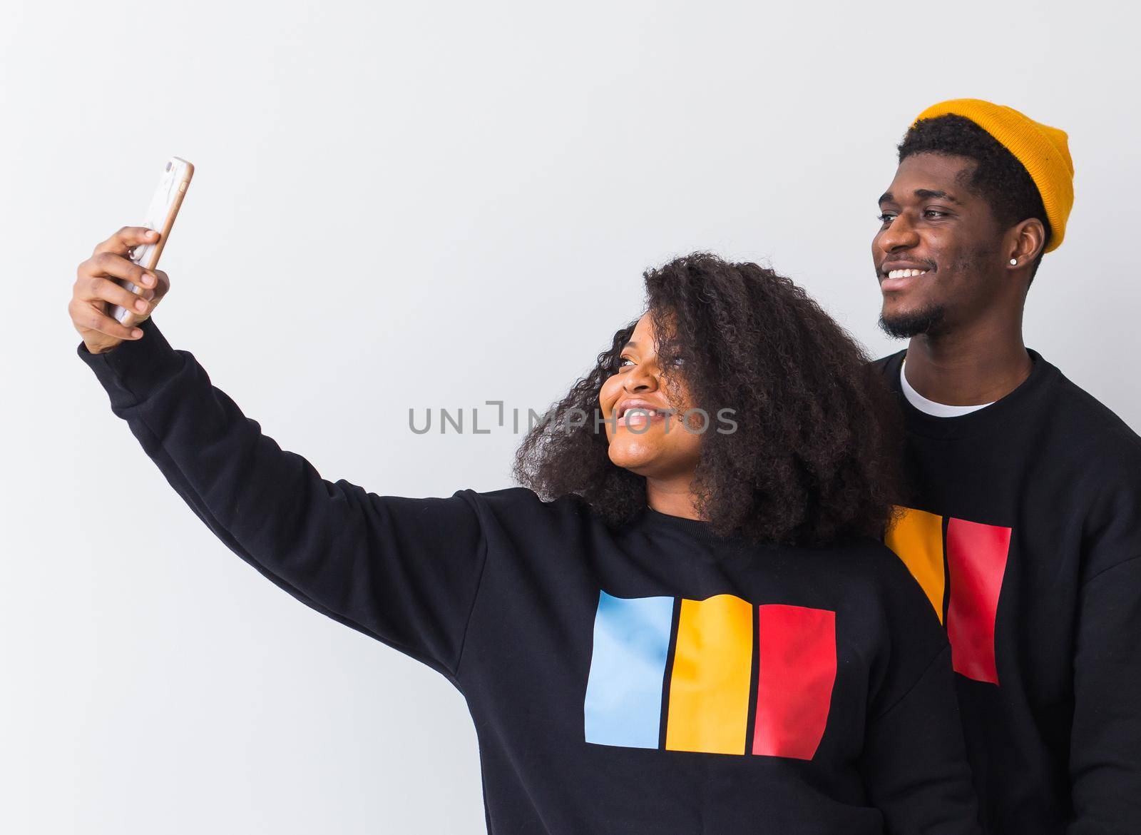 Friendship and fun concept - Group of friends afro american men and woman taking selfie in studio on white background