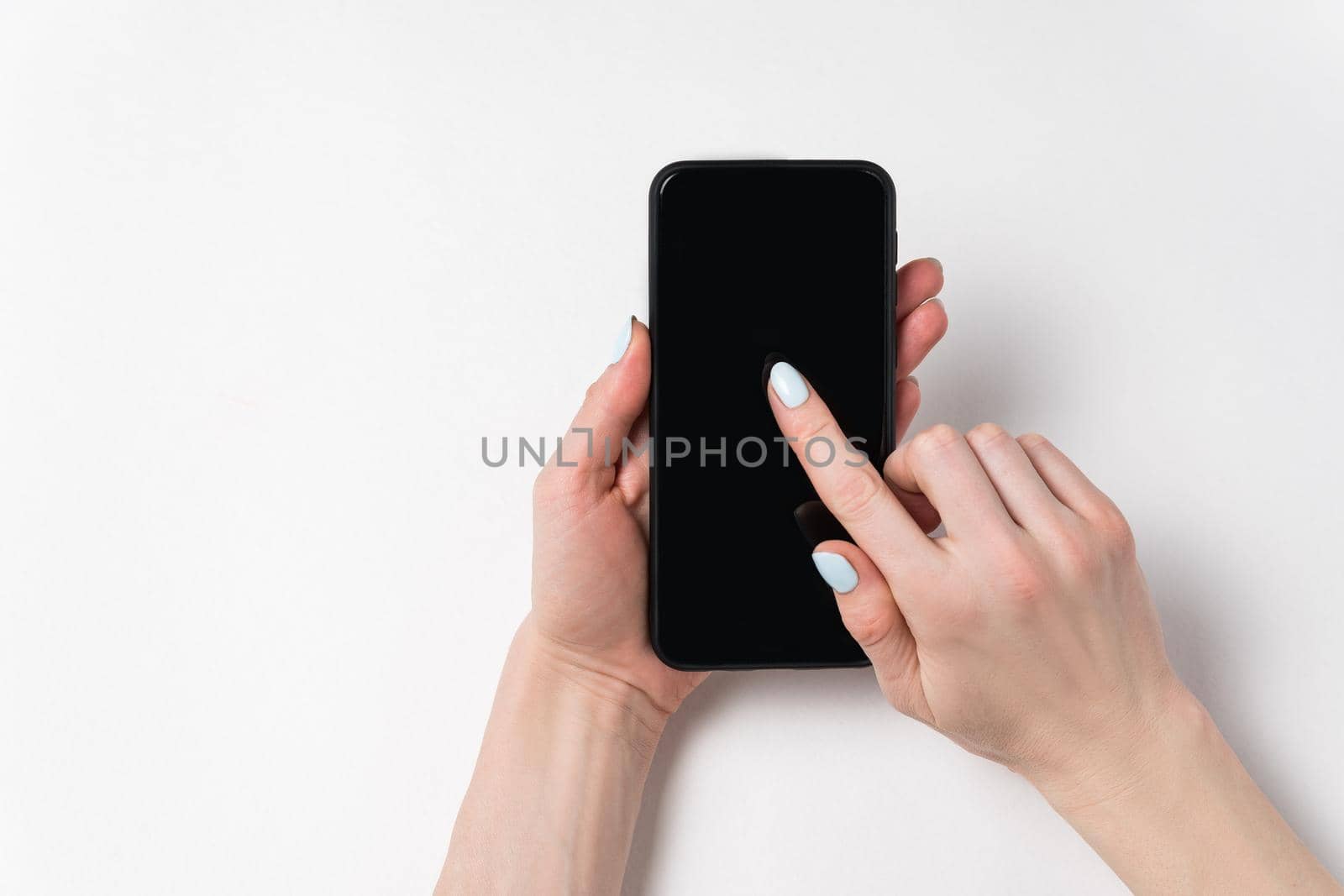 Female hands holding phone and showing on screen. Black display, white background, copy space.