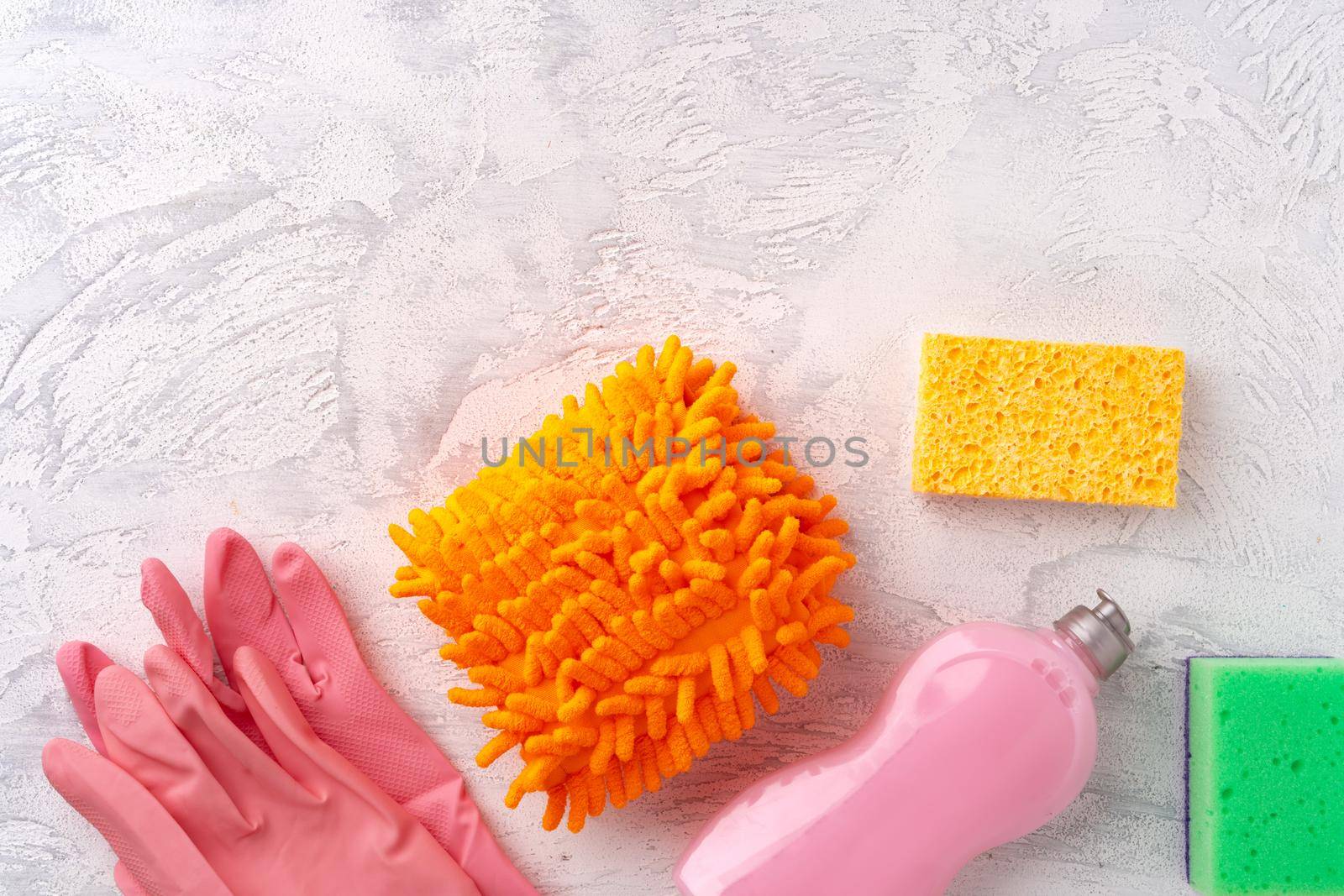Home cleaning supplies on white wooden background, top view photo