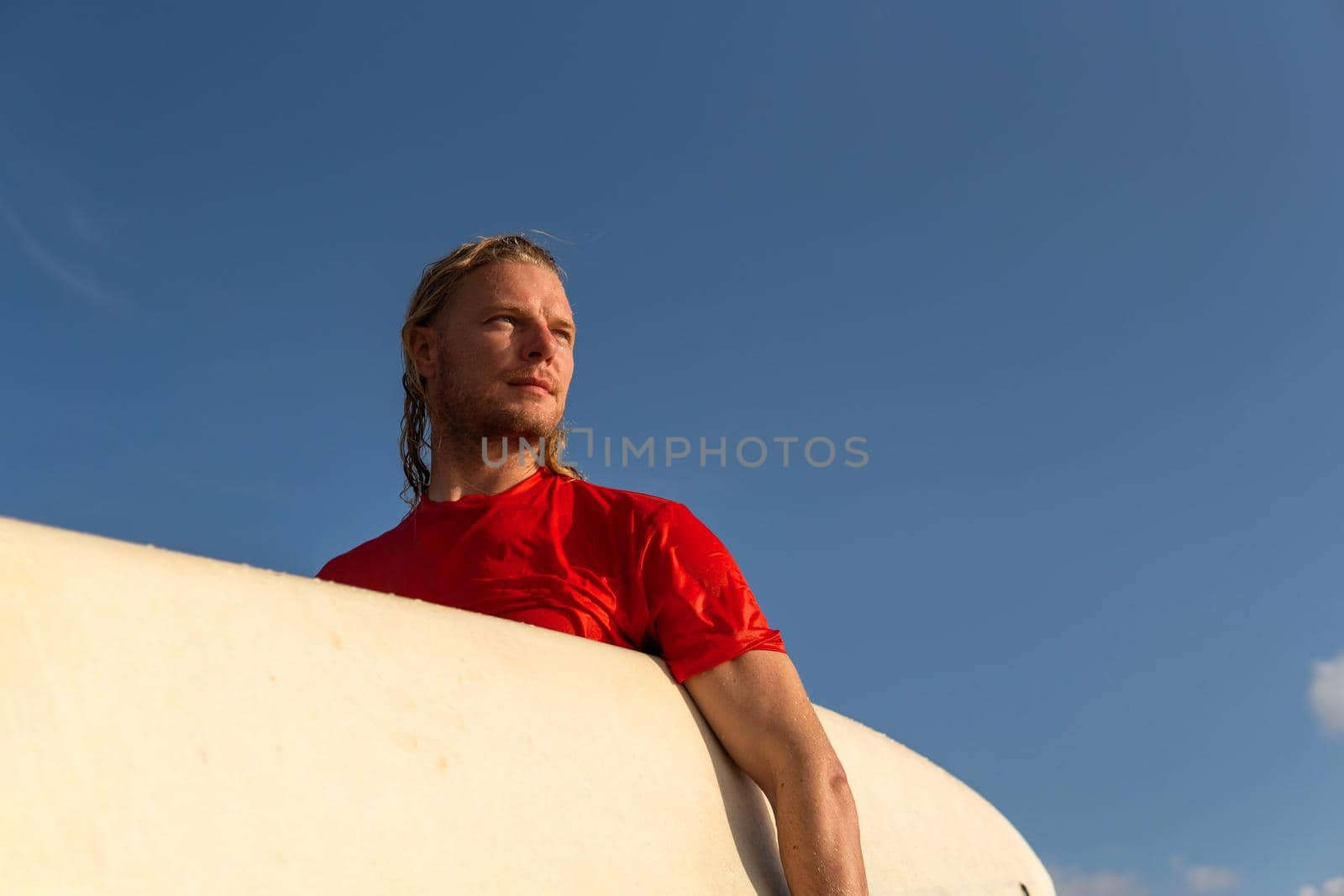 surfer man in red portrait with surfboard. bali