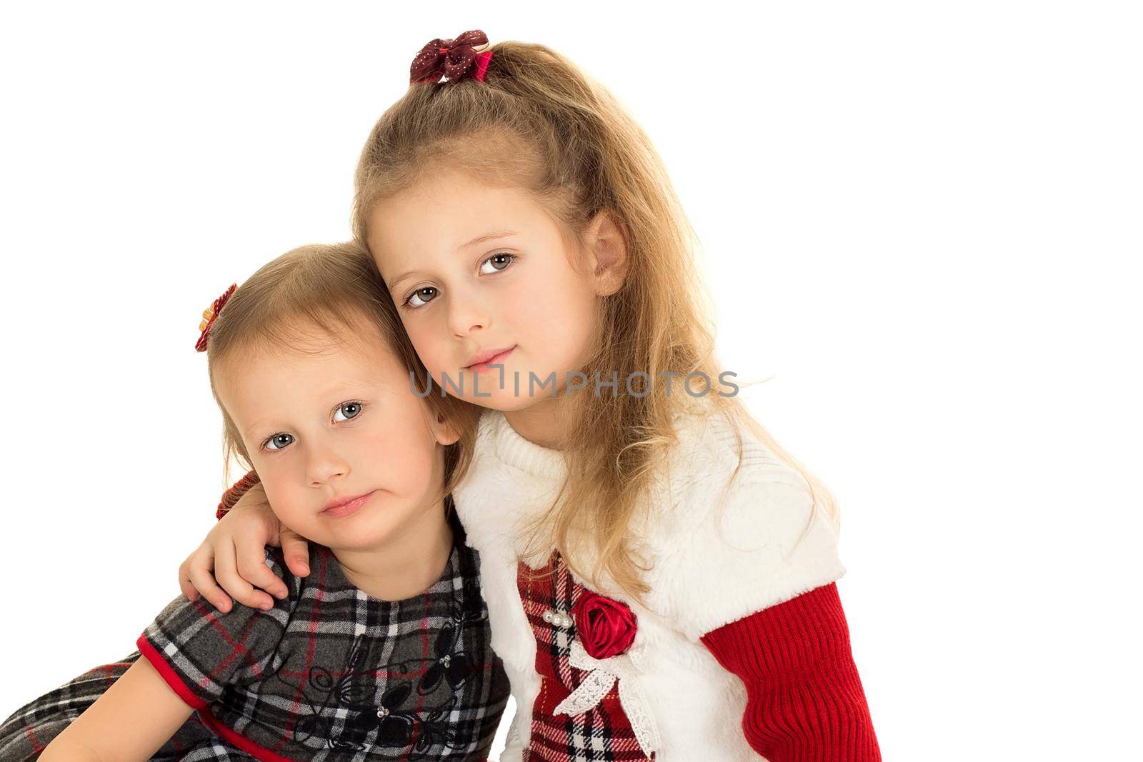 Two sisters hugging and sitting on the floor - Isolated on white background
