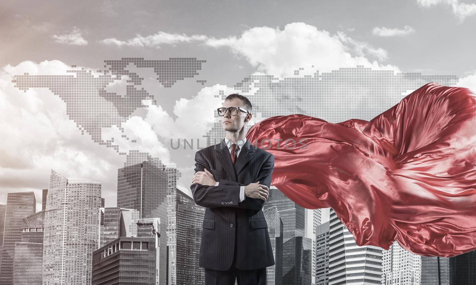 Young confident businessman wearing red cape against modern city background