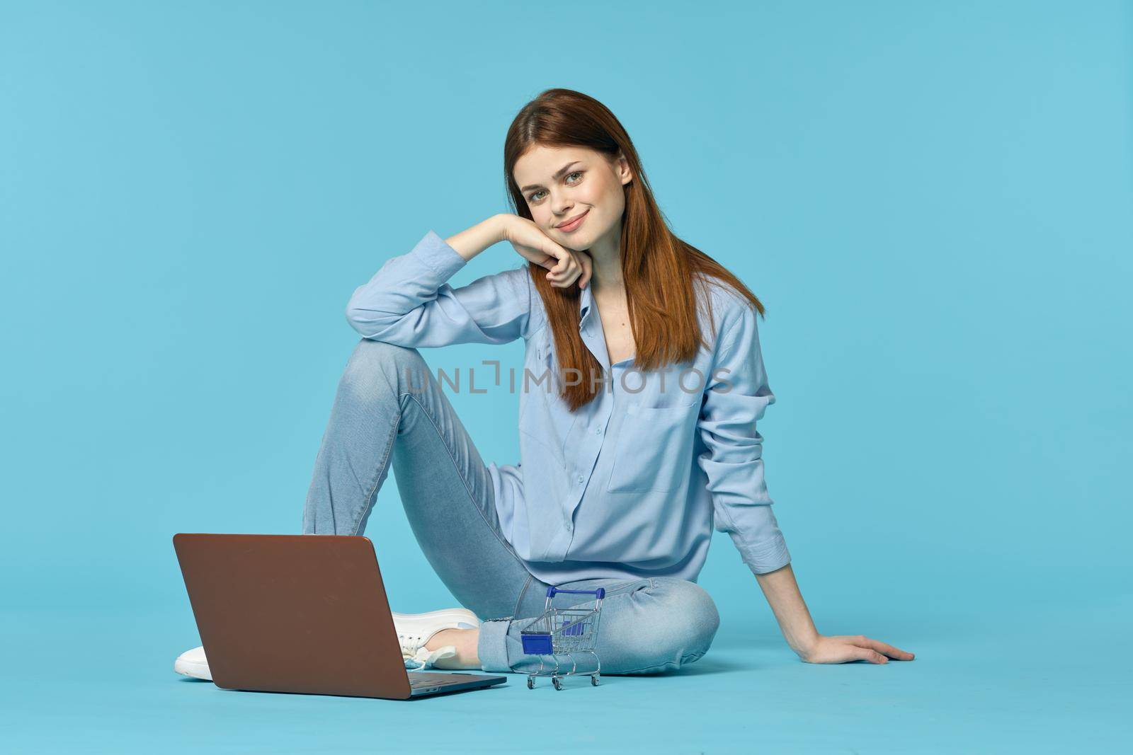 woman with laptop learning internet online education blue background. High quality photo