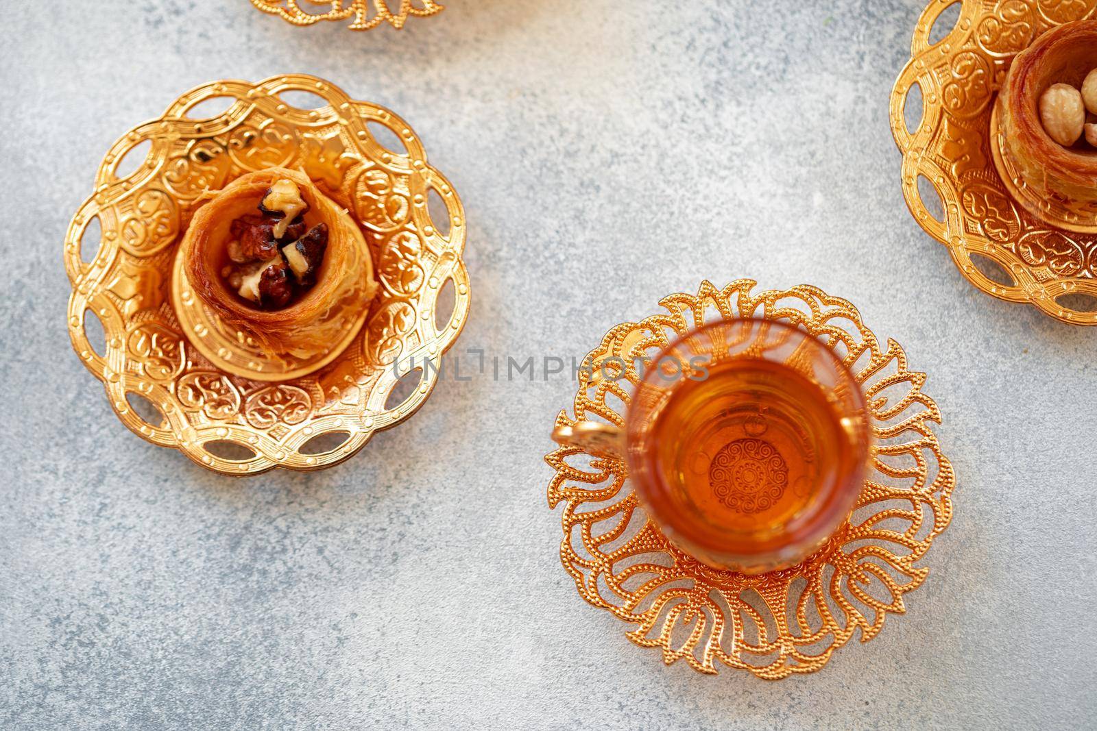 Turkish baklava and Turkish tea in oriental dishes on gray background, close up
